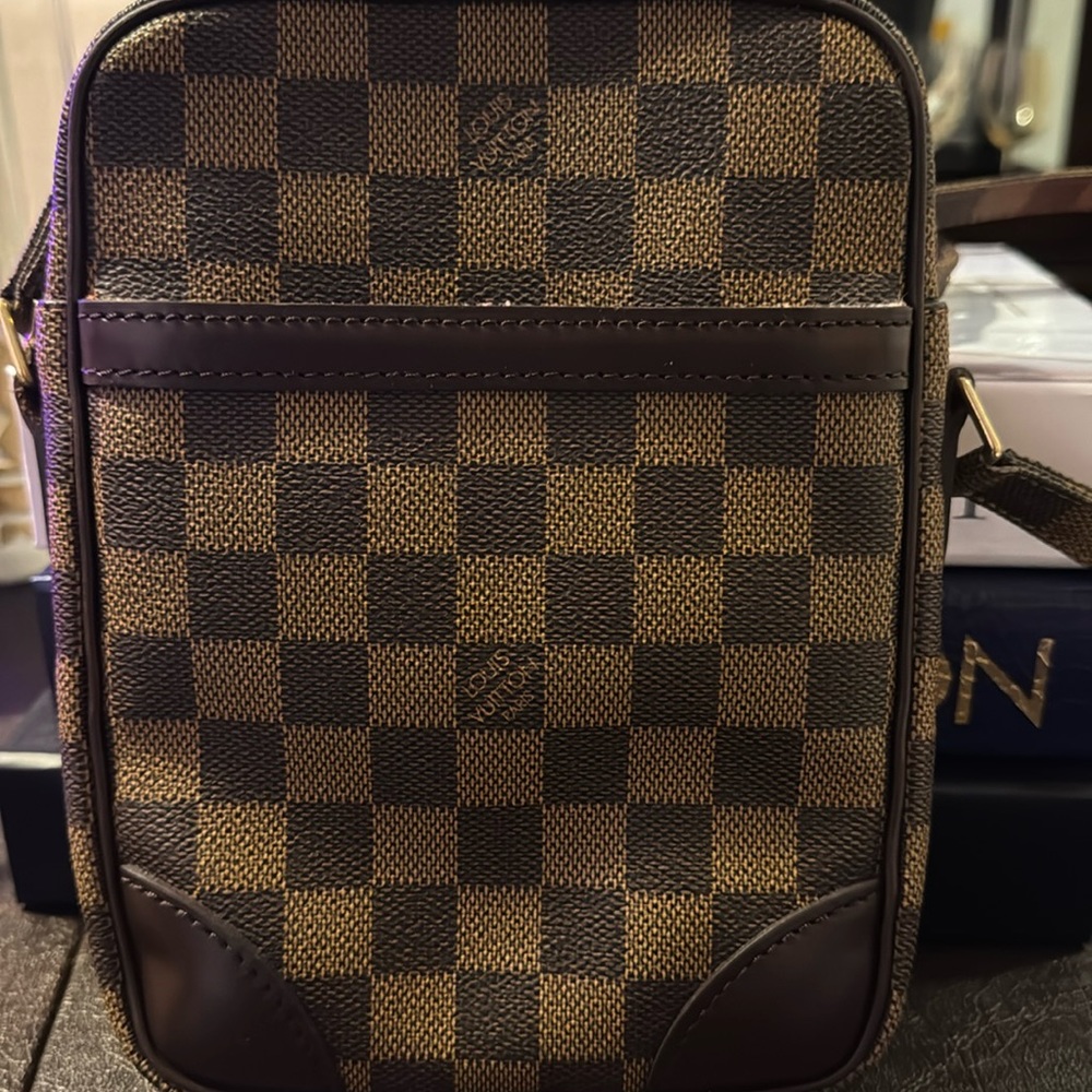 Gently used LV Danube Damier pattern with gold-tone zipper and adjustable strap